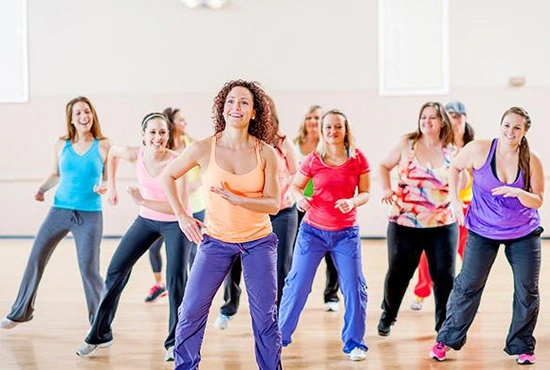 Vrouwen bewegen en maken plezier tijdens een rustige groeples Zumba fitness in de fitnesszaal van LAGO CLUB Grimbergen.
