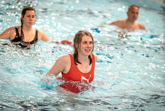 Vrouwen en mannen volgen een aquagymles in groep in het zwembad van LAGO CLUB fitness Grimbergen. 